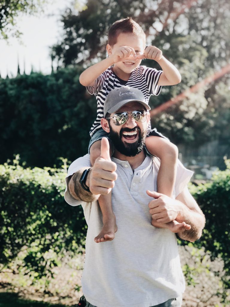 parent with beard with young boy on his shoulders
