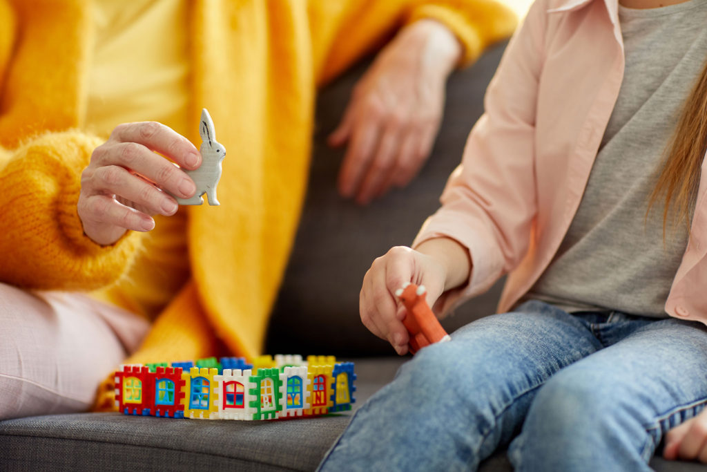 Child and counselor playing with animal toys