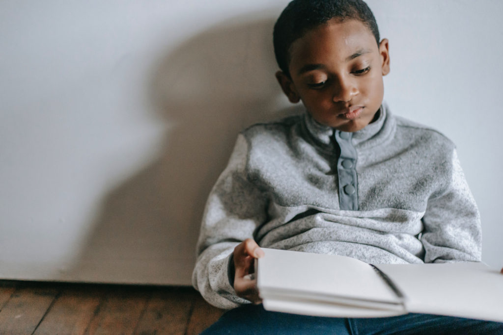 Young unmotivated child looking down at his notebook