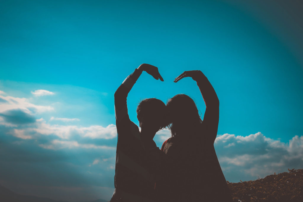 Silhouette of couple making a heart sign