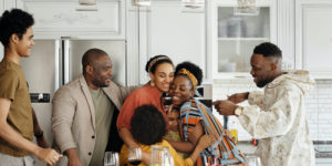 Family smiling and hugging in the kitchen